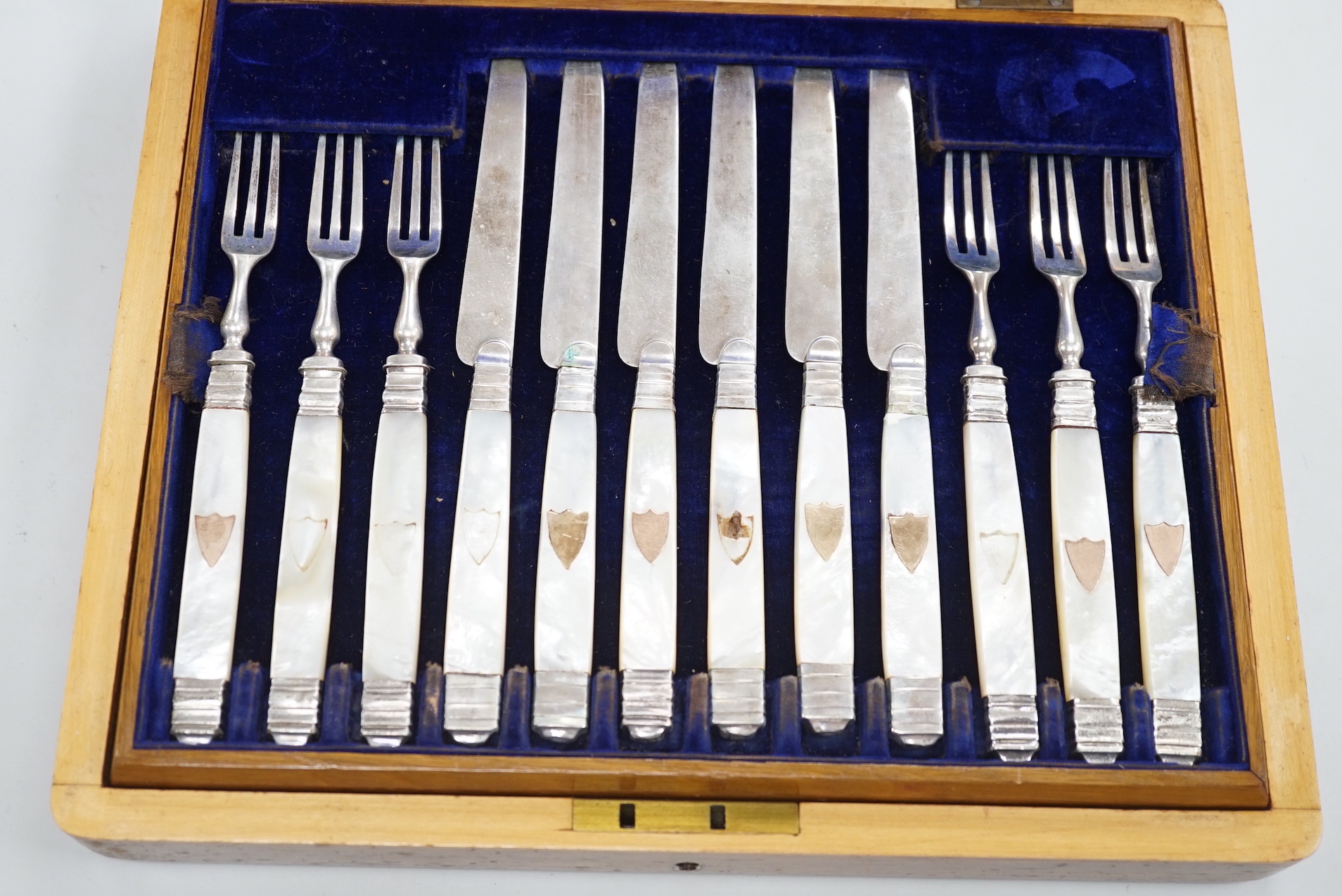 A cased set of twelve pairs of 19th century French mother of pearl handled white metal dessert eaters (one fork a.f.).